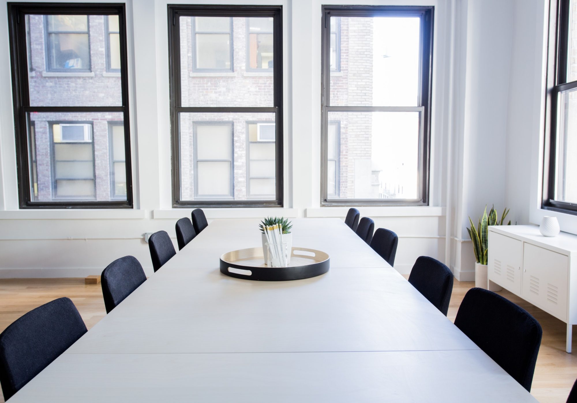 Minimalist conference room with a long table overlooking a city street