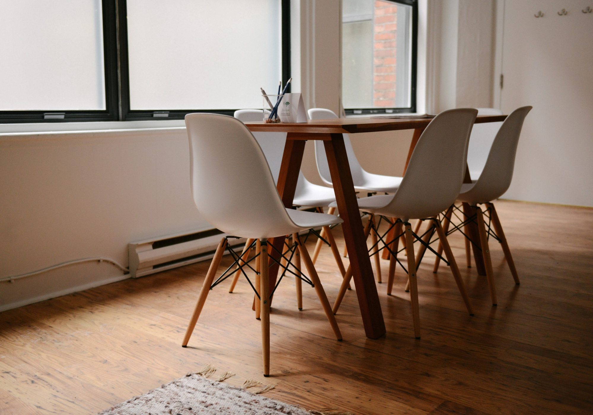 Warm, quiet meeting room with a wooden table and chairs by a window